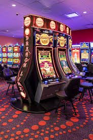 Meja kasino dengan kartu remi dan roda roulette yang menggambarkan hiburan kasino online